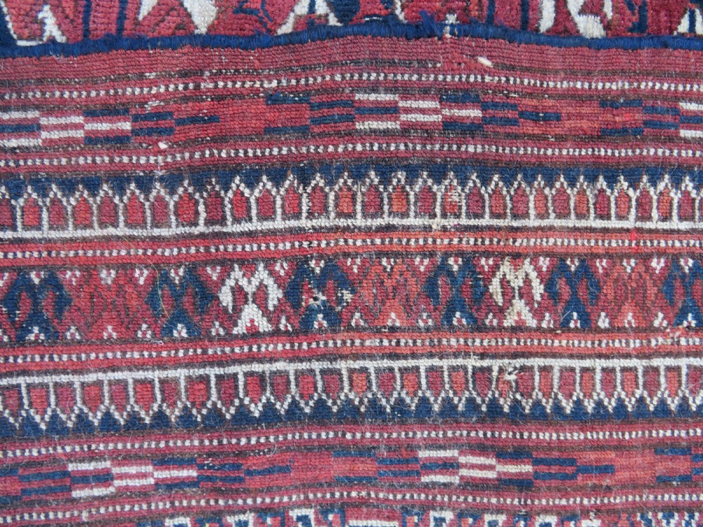 An antique Tekke Turkmen main carpet and matching runner featuring traditional repeating gul motifs in deep red, navy blue, and ivory hand-woven wool. View XVI