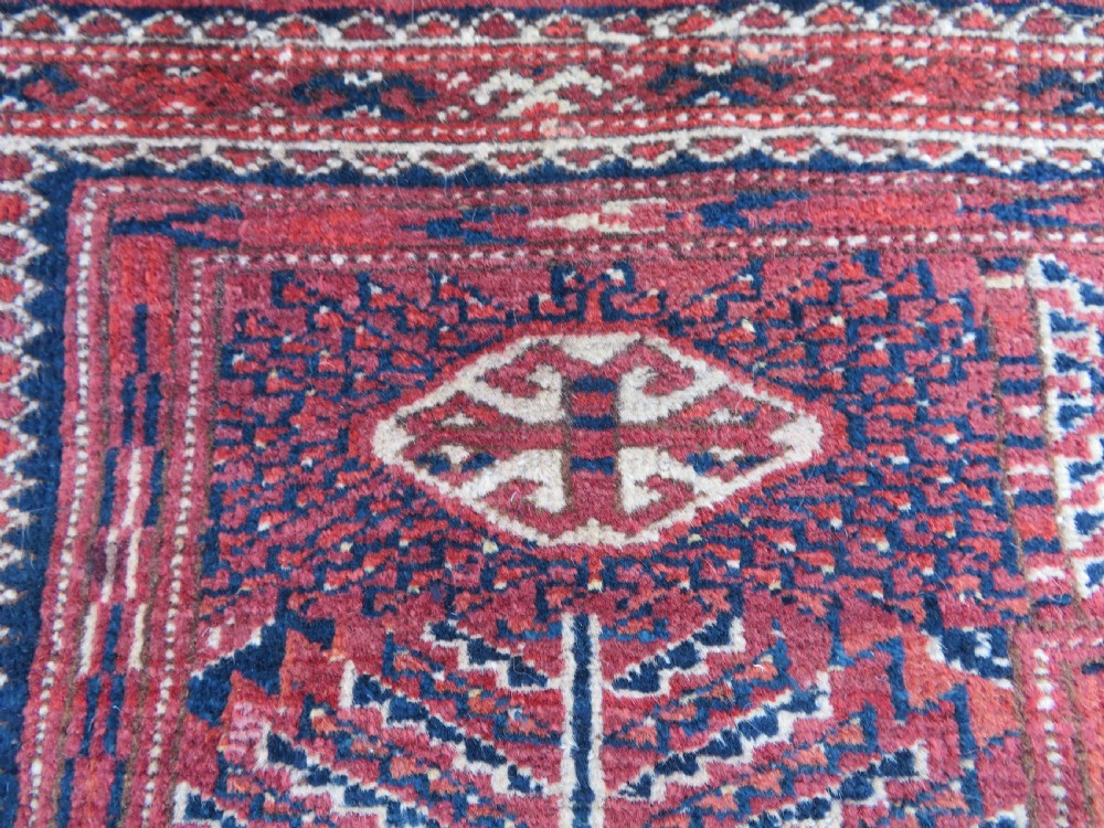 An antique Tekke Turkmen main carpet and matching runner featuring traditional repeating gul motifs in deep red, navy blue, and ivory hand-woven wool. View XXIV