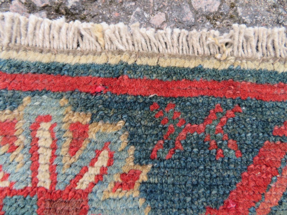 A long, narrow hand-knotted wool runner featuring a repeating geometric Mina Khana floral lattice pattern in navy blue, terracotta red, and cream tones. View IX