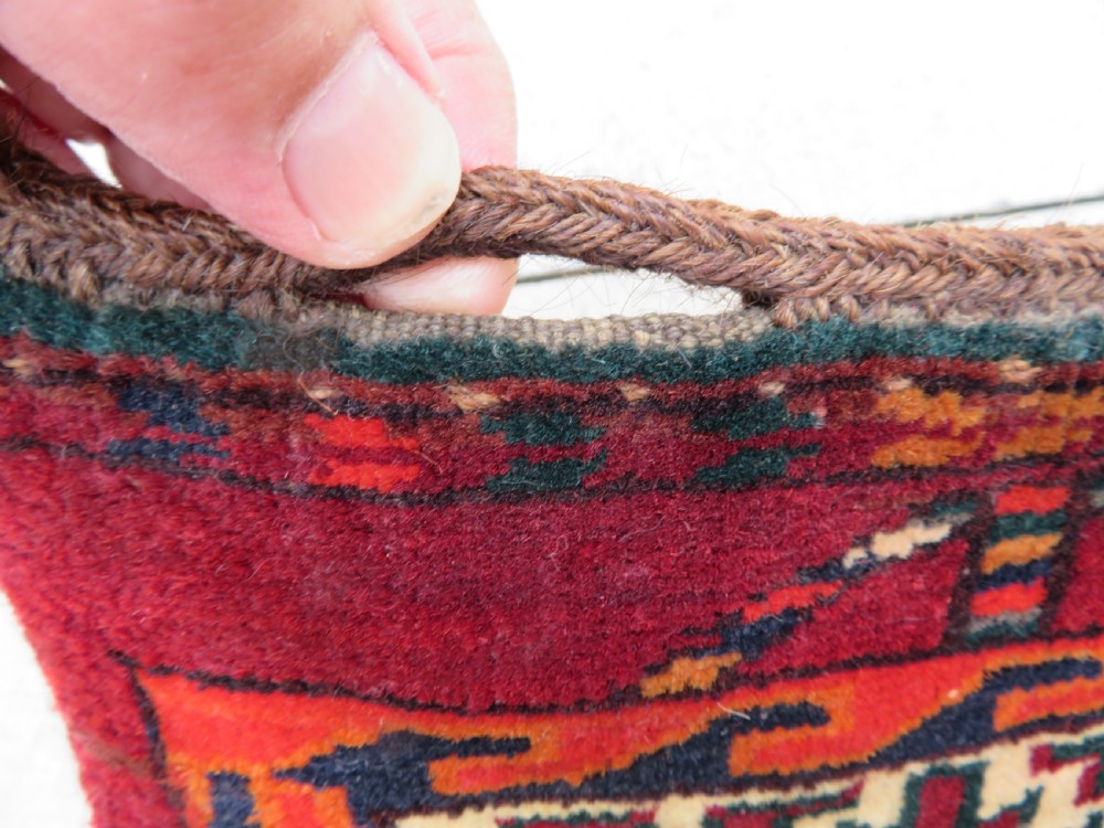 An antique woven Yomut Turkmen chuval rug in deep red wool featuring nine central geometric gul motifs surrounded by a patterned border and a detailed lower elem panel. View XI