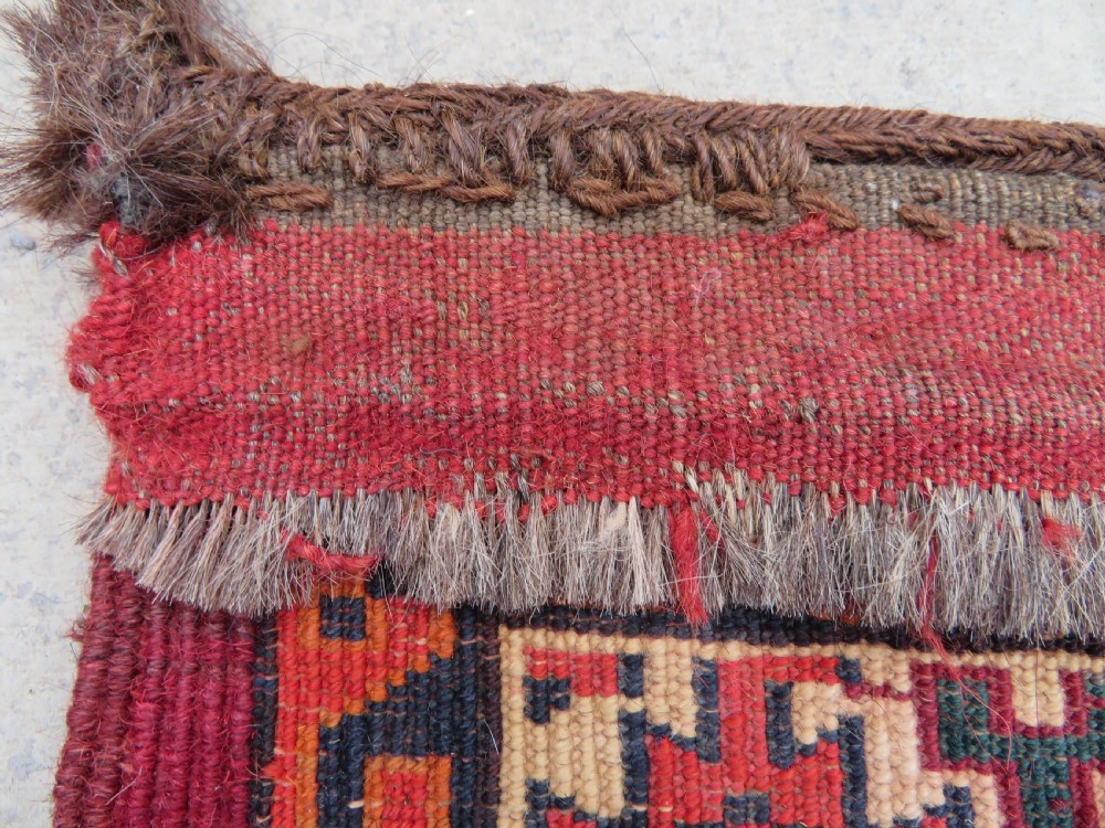 An antique woven Yomut Turkmen chuval rug in deep red wool featuring nine central geometric gul motifs surrounded by a patterned border and a detailed lower elem panel. View XXI