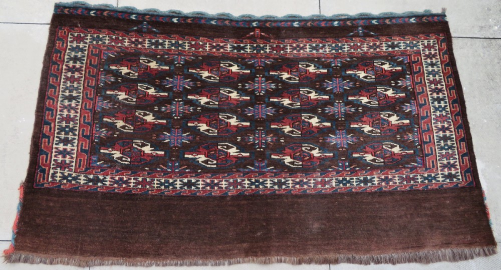 A rectangular hand-woven Yomut Turkmen wool chuval bag face featuring sixteen repeating central guls framed by geometric borders and a solid dark brown lower elem skirt.