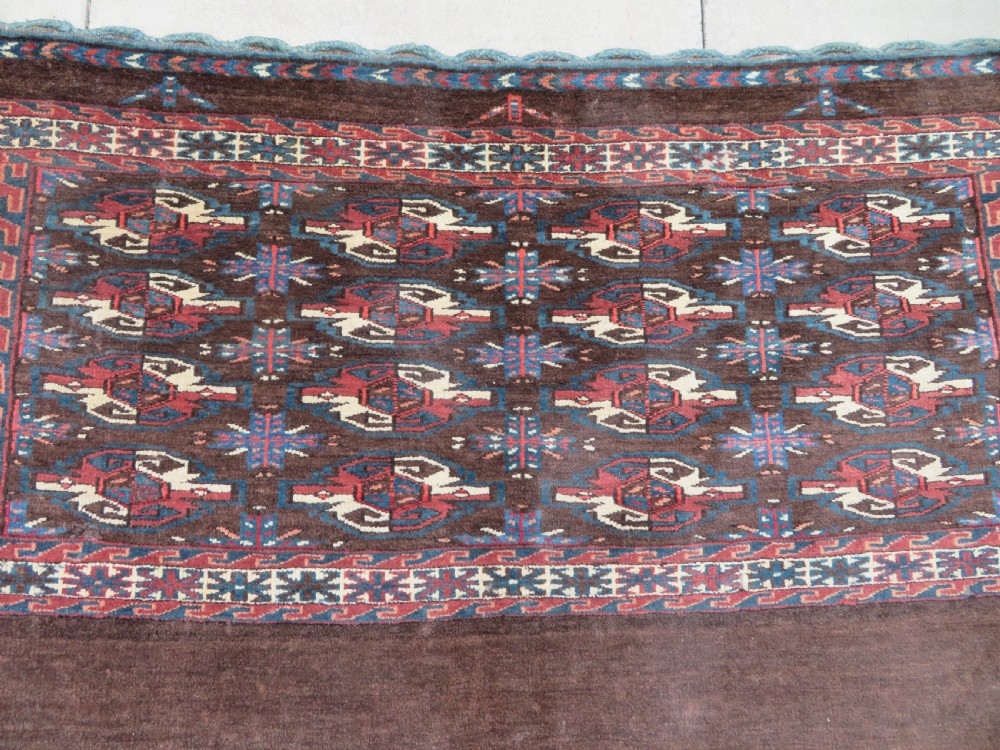 A rectangular hand-woven Yomut Turkmen wool chuval bag face featuring sixteen repeating central guls framed by geometric borders and a solid dark brown lower elem skirt. View III