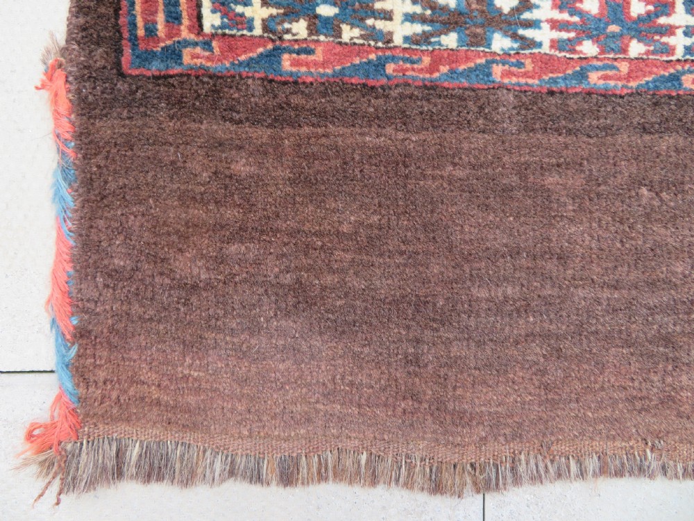 A rectangular hand-woven Yomut Turkmen wool chuval bag face featuring sixteen repeating central guls framed by geometric borders and a solid dark brown lower elem skirt. View VI