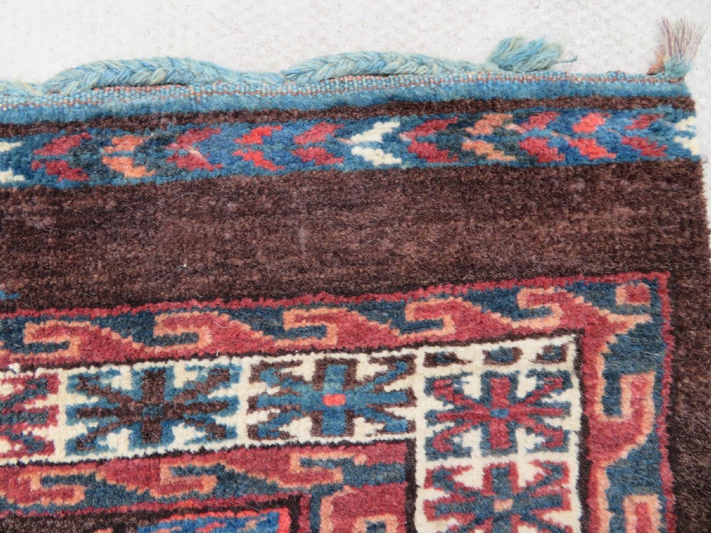A rectangular hand-woven Yomut Turkmen wool chuval bag face featuring sixteen repeating central guls framed by geometric borders and a solid dark brown lower elem skirt. View IX