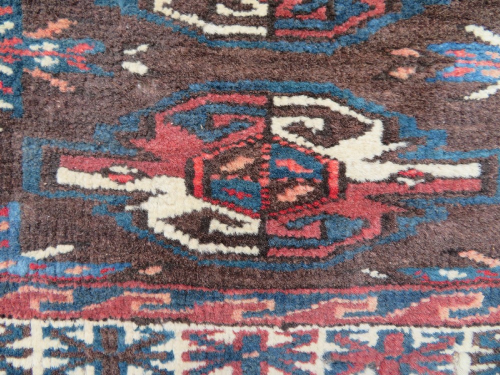 A rectangular hand-woven Yomut Turkmen wool chuval bag face featuring sixteen repeating central guls framed by geometric borders and a solid dark brown lower elem skirt. View XIII