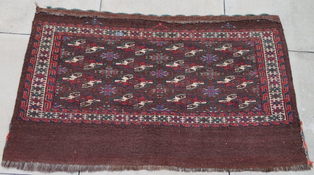 A rectangular hand-woven Yomut Turkmen wool chuval bag face featuring sixteen repeating central guls framed by geometric borders and a solid dark brown lower elem skirt. View XVI