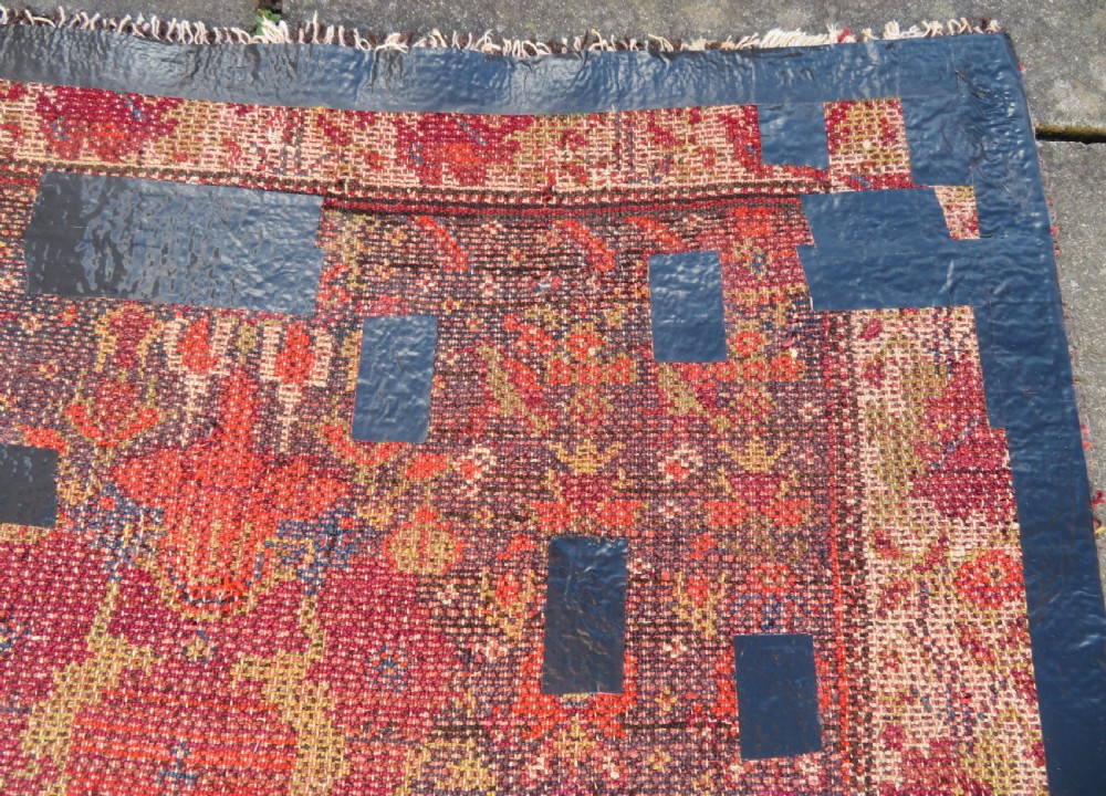 A rectangular hand-knotted antique Kurdish wool rug featuring red, navy blue, and cream tribal motifs with a decorated floral border. View XXVIII