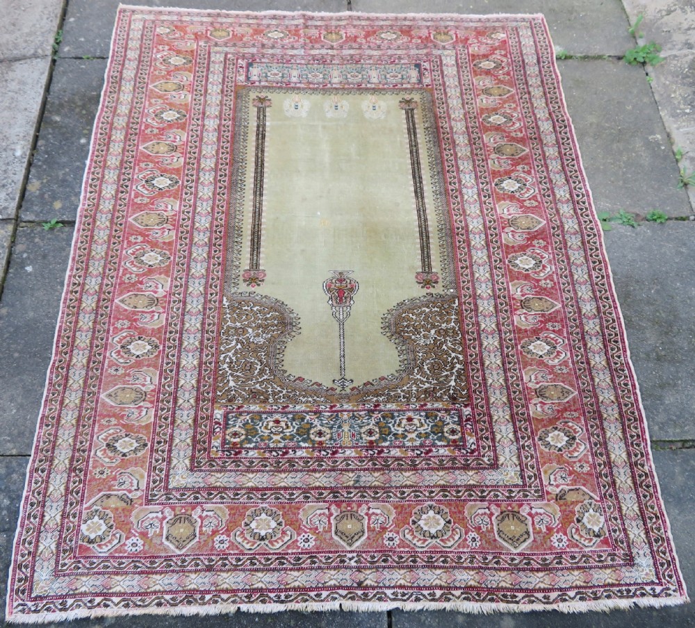 An antique Turkish Kayseri prayer rug featuring a central pale pistachio green field with a mihrab niche surrounded by intricate floral borders in coral pink and cream. View II