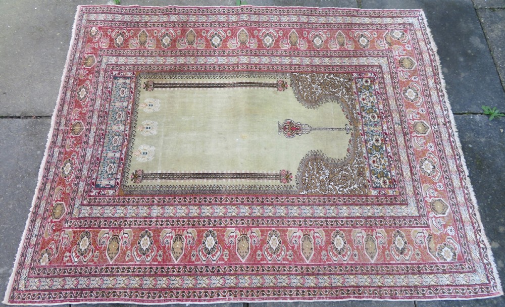 An antique Turkish Kayseri prayer rug featuring a central pale pistachio green field with a mihrab niche surrounded by intricate floral borders in coral pink and cream. View IV