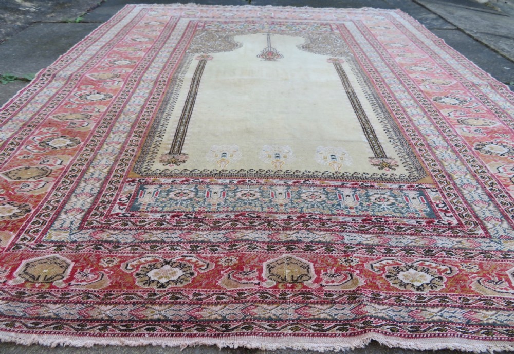 An antique Turkish Kayseri prayer rug featuring a central pale pistachio green field with a mihrab niche surrounded by intricate floral borders in coral pink and cream. View VI