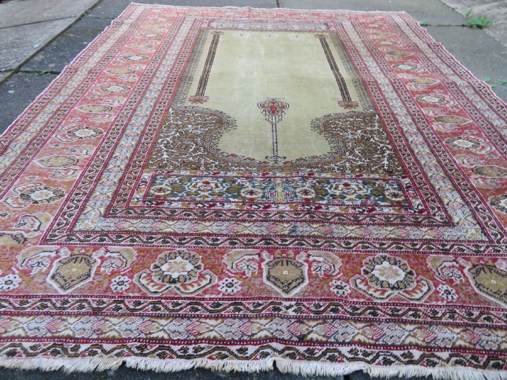 An antique Turkish Kayseri prayer rug featuring a central pale pistachio green field with a mihrab niche surrounded by intricate floral borders in coral pink and cream. View VII