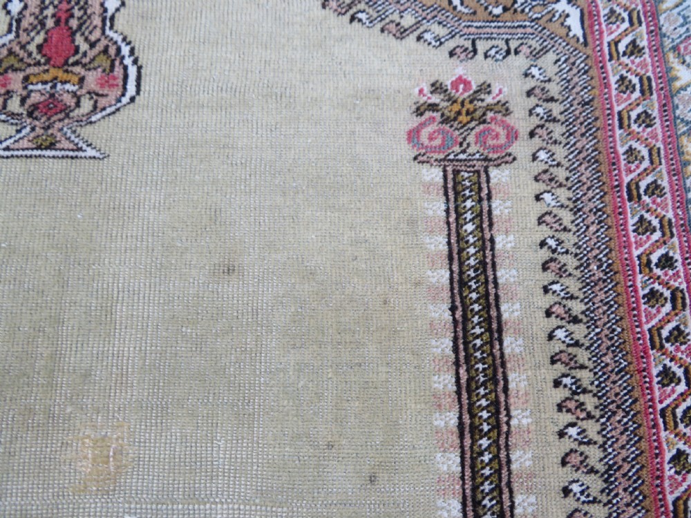An antique Turkish Kayseri prayer rug featuring a central pale pistachio green field with a mihrab niche surrounded by intricate floral borders in coral pink and cream. View XII