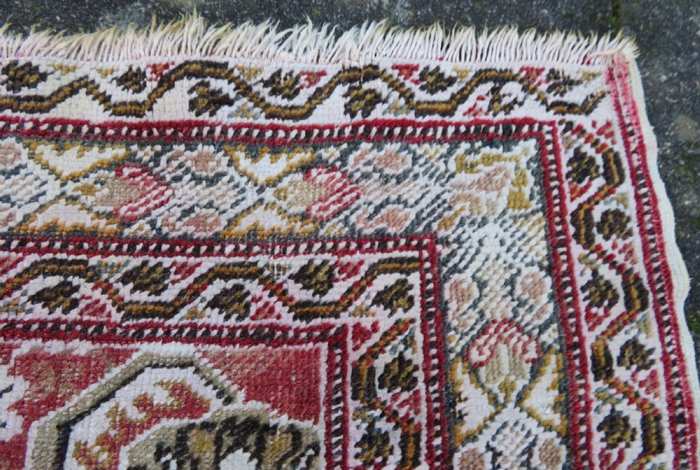 An antique Turkish Kayseri prayer rug featuring a central pale pistachio green field with a mihrab niche surrounded by intricate floral borders in coral pink and cream. View XVIII