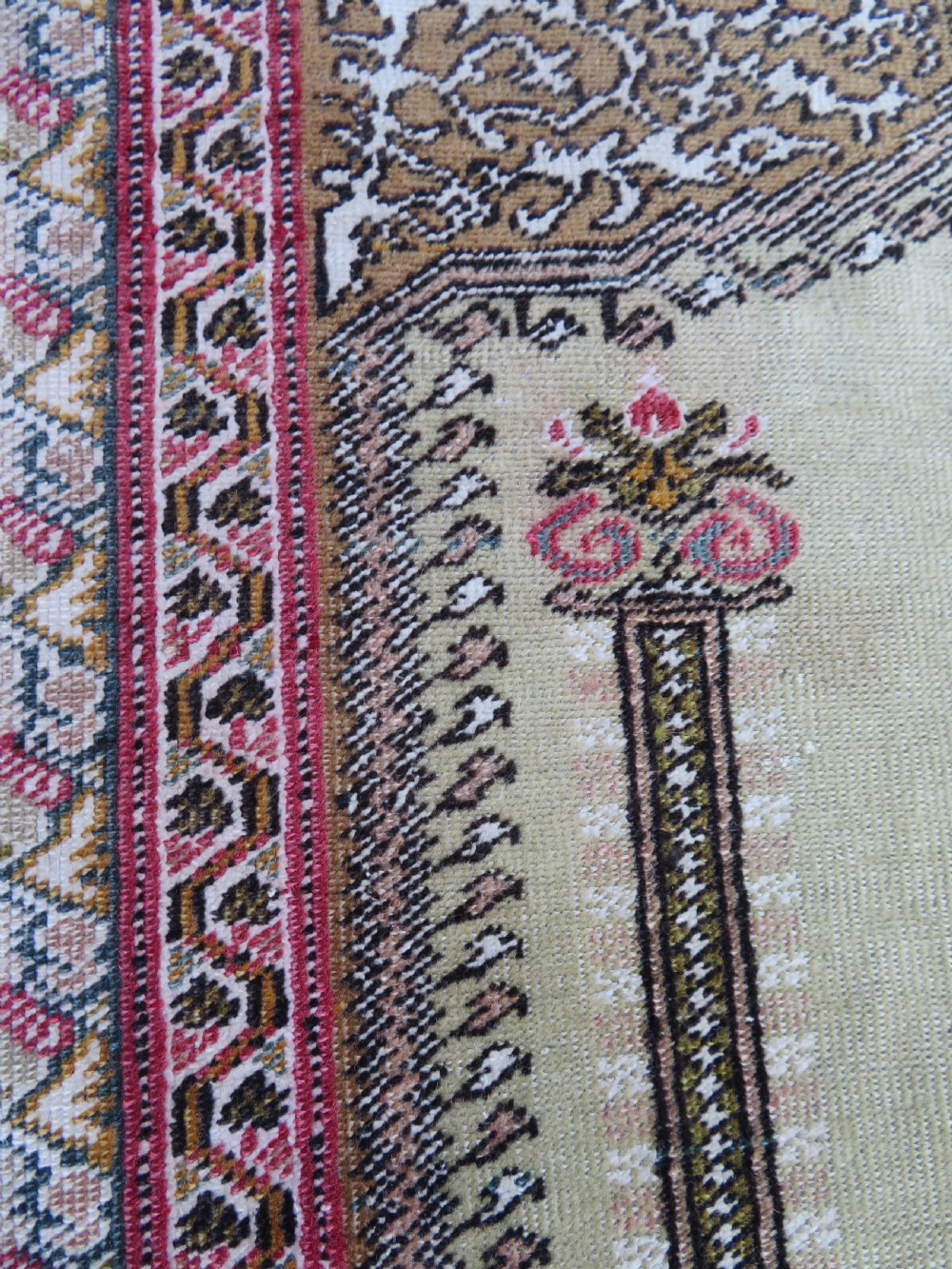 An antique Turkish Kayseri prayer rug featuring a central pale pistachio green field with a mihrab niche surrounded by intricate floral borders in coral pink and cream. View XIX
