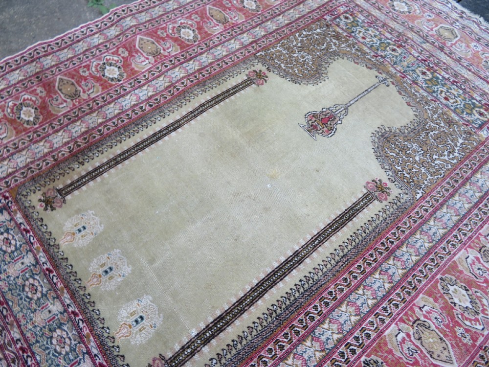An antique Turkish Kayseri prayer rug featuring a central pale pistachio green field with a mihrab niche surrounded by intricate floral borders in coral pink and cream. View XXI