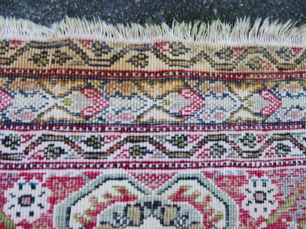 An antique Turkish Kayseri prayer rug featuring a central pale pistachio green field with a mihrab niche surrounded by intricate floral borders in coral pink and cream. View XXV