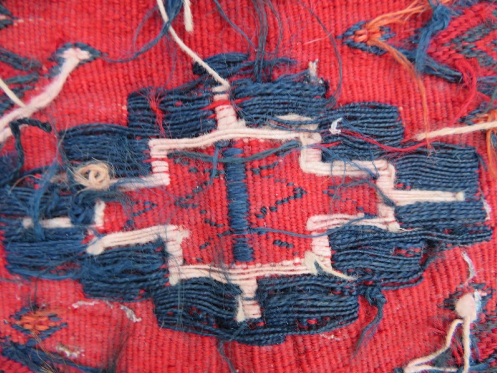 Mid-nineteenth century Turkmen chuval textile featuring repeated geometric gul medallions woven in navy blue and ivory against a crimson red field with a flat-woven lower section. View XVI