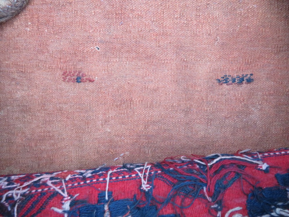 Mid-nineteenth century Turkmen chuval textile featuring repeated geometric gul medallions woven in navy blue and ivory against a crimson red field with a flat-woven lower section. View XVII