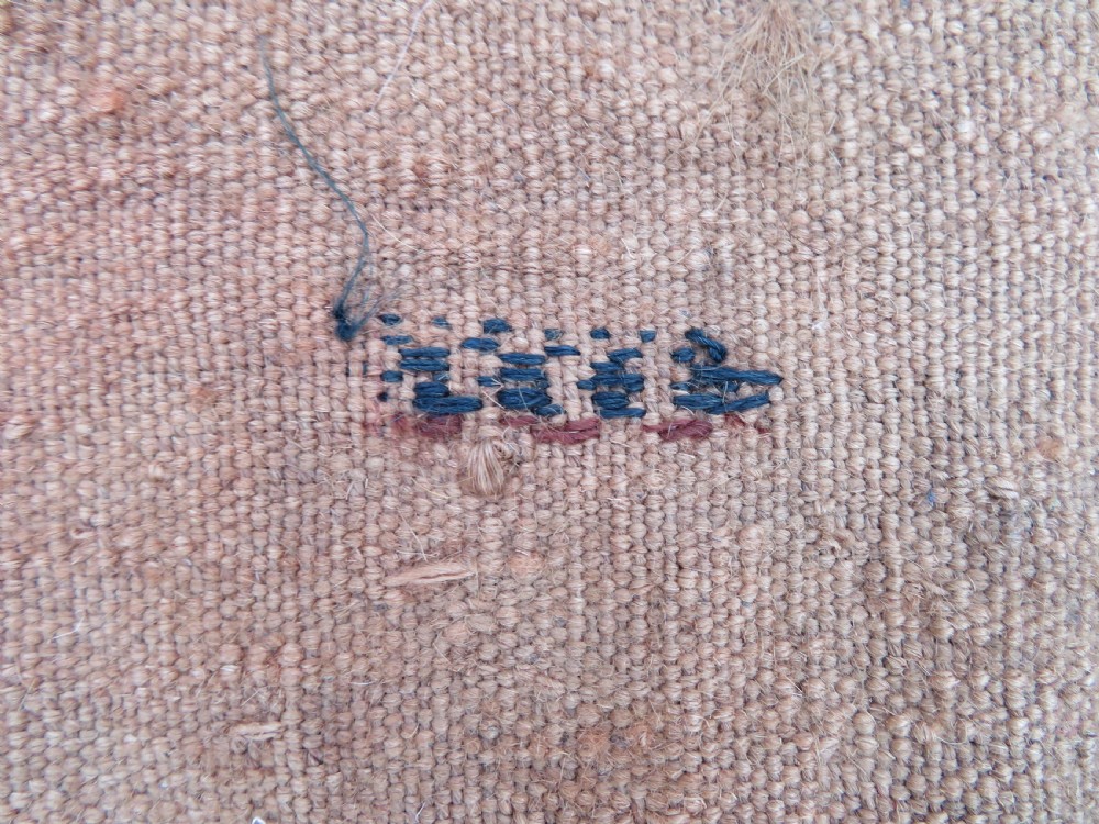Mid-nineteenth century Turkmen chuval textile featuring repeated geometric gul medallions woven in navy blue and ivory against a crimson red field with a flat-woven lower section. View XXI