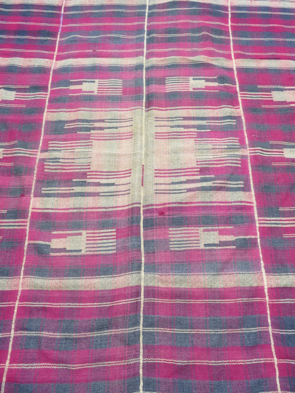 A rectangular flat-woven wool textile featuring crimson, navy, and cream geometric checked patterns with fringed ends. View VIII