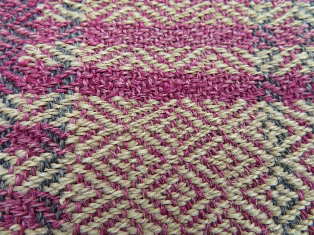 A rectangular flat-woven wool textile featuring crimson, navy, and cream geometric checked patterns with fringed ends. View IX