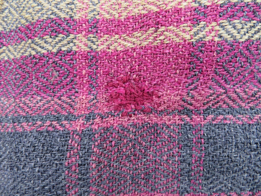 A rectangular flat-woven wool textile featuring crimson, navy, and cream geometric checked patterns with fringed ends. View XI