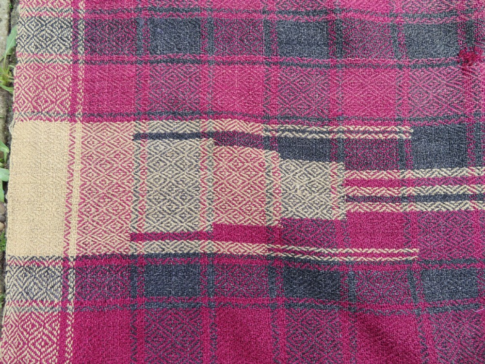 A rectangular flat-woven wool textile featuring crimson, navy, and cream geometric checked patterns with fringed ends. View XIV