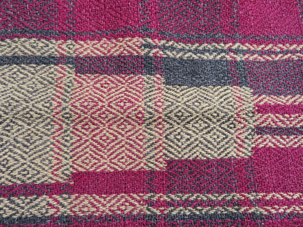 A rectangular flat-woven wool textile featuring crimson, navy, and cream geometric checked patterns with fringed ends. View XV
