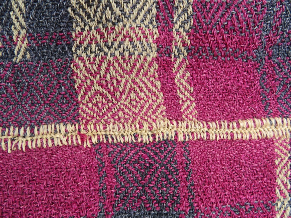 A rectangular flat-woven wool textile featuring crimson, navy, and cream geometric checked patterns with fringed ends. View XVIII