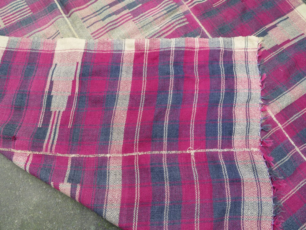 A rectangular flat-woven wool textile featuring crimson, navy, and cream geometric checked patterns with fringed ends. View XX