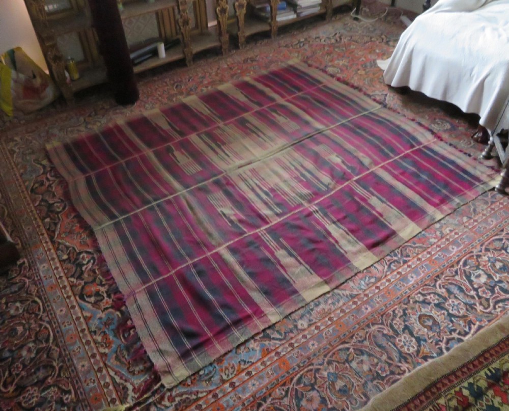 A rectangular flat-woven wool textile featuring crimson, navy, and cream geometric checked patterns with fringed ends. View XXV