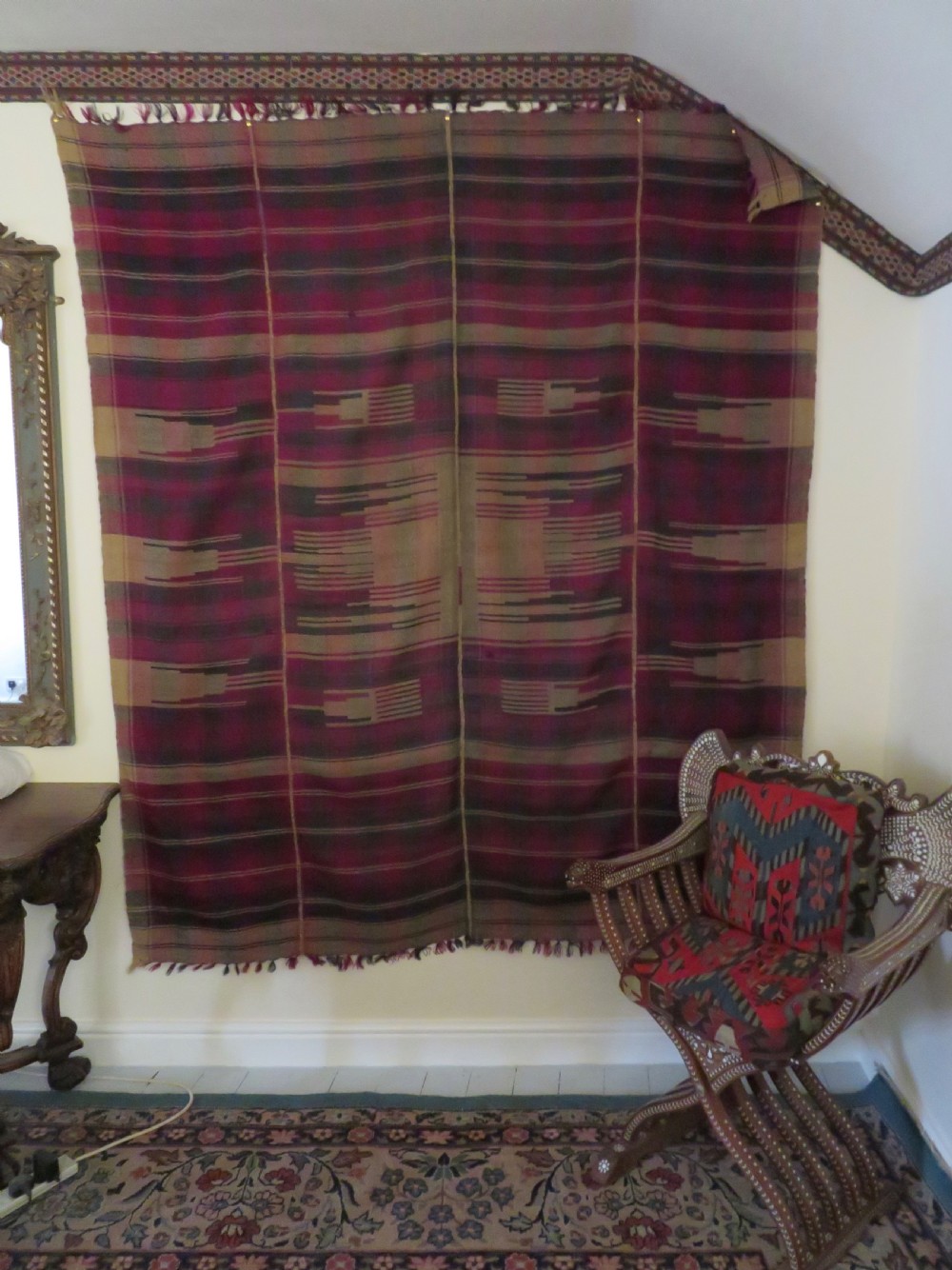 A rectangular flat-woven wool textile featuring crimson, navy, and cream geometric checked patterns with fringed ends. View XXVII