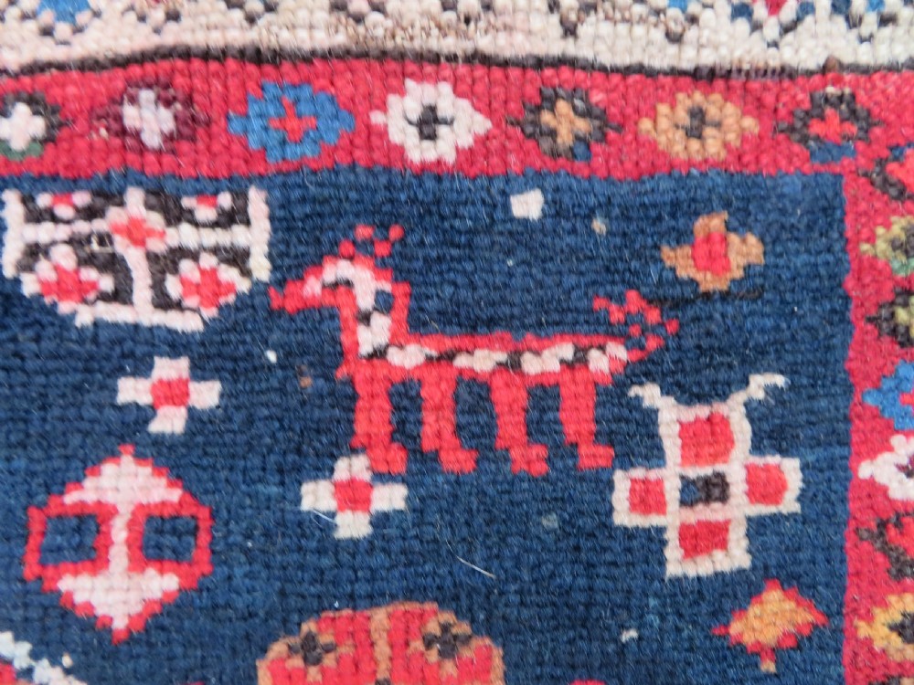 An antique late 19th-century Caucasian Kuba Konagkend wool rug featuring red geometric medallions set against a dark navy field with multi-coloured borders. View VII