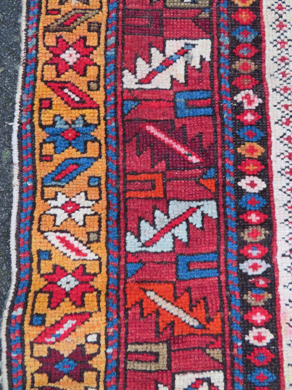 An antique late 19th-century Caucasian Kuba Konagkend wool rug featuring red geometric medallions set against a dark navy field with multi-coloured borders. View XXII