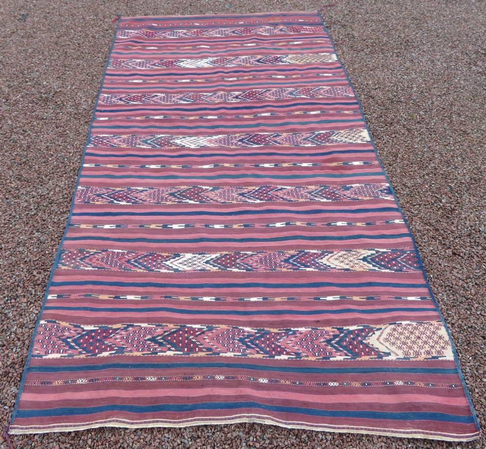 A rectangular handwoven Tekke Turkmen flatweave rug with horizontal striped bands of red, navy, and ivory wool.