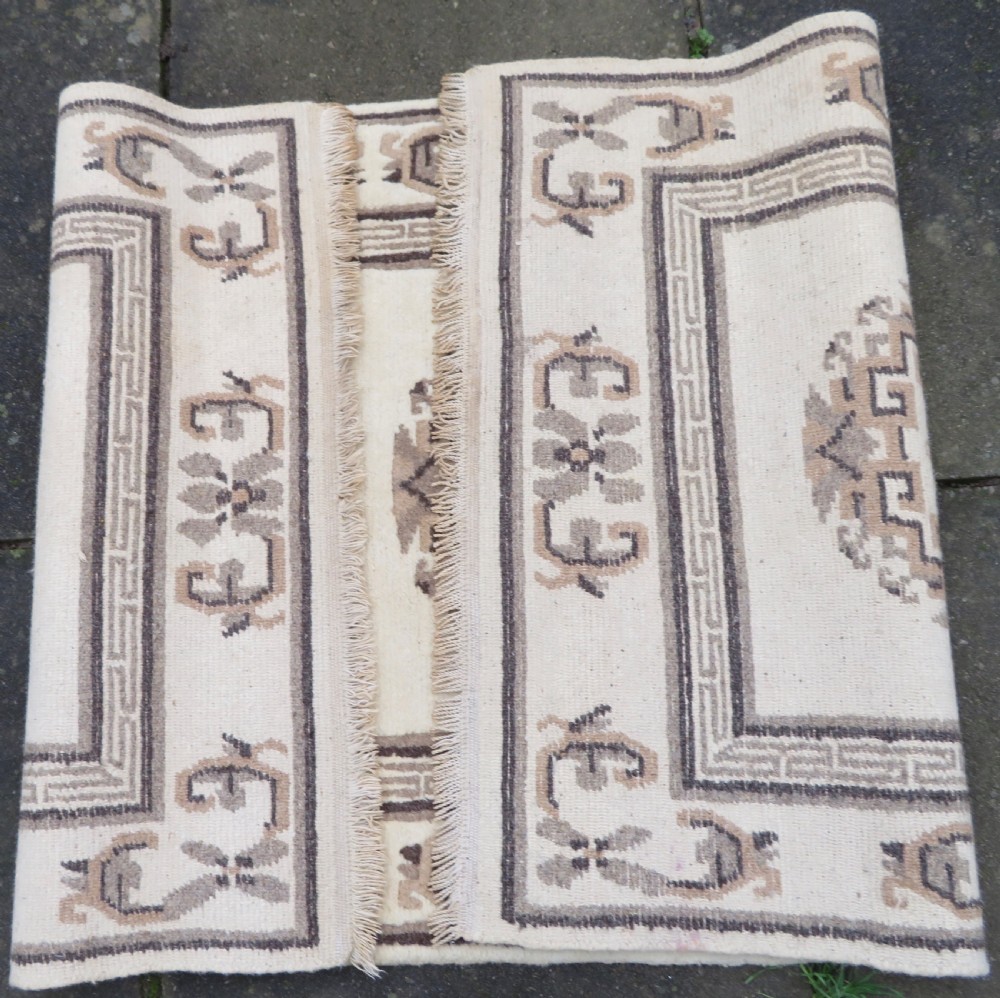 A rectangular hand-knotted wool rug runner featuring three central brown circular medallions on a cream background with a geometric border. View XV
