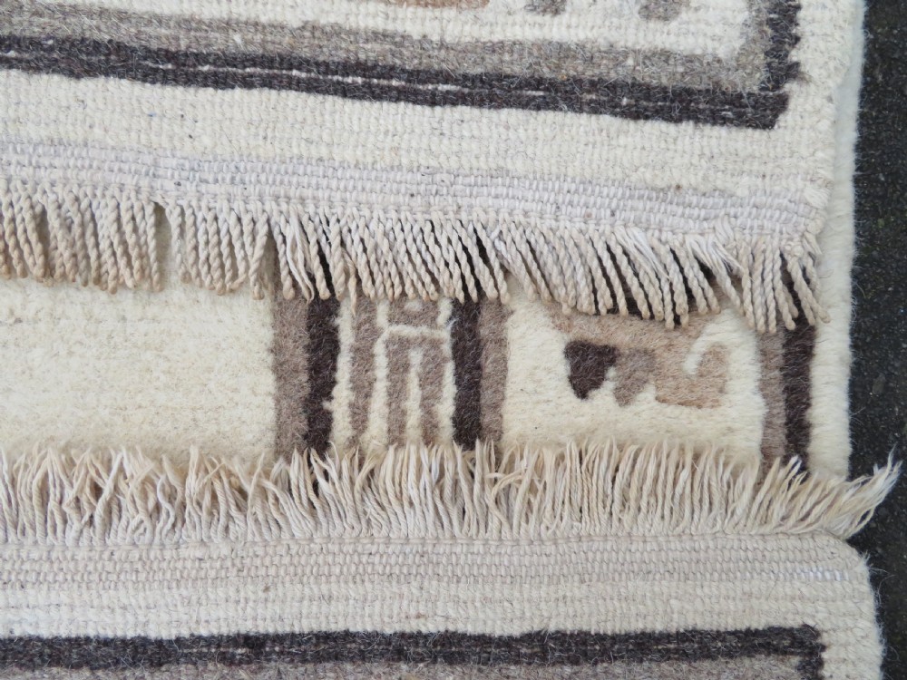 A rectangular hand-knotted wool rug runner featuring three central brown circular medallions on a cream background with a geometric border. View XVI