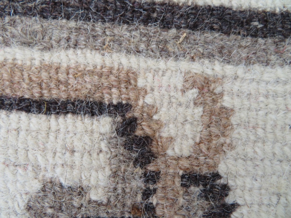 A rectangular hand-knotted wool rug runner featuring three central brown circular medallions on a cream background with a geometric border. View XVII