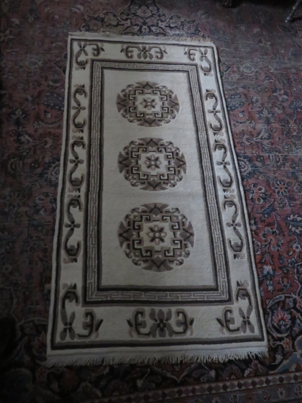 A rectangular hand-knotted wool rug runner featuring three central brown circular medallions on a cream background with a geometric border. View XIX