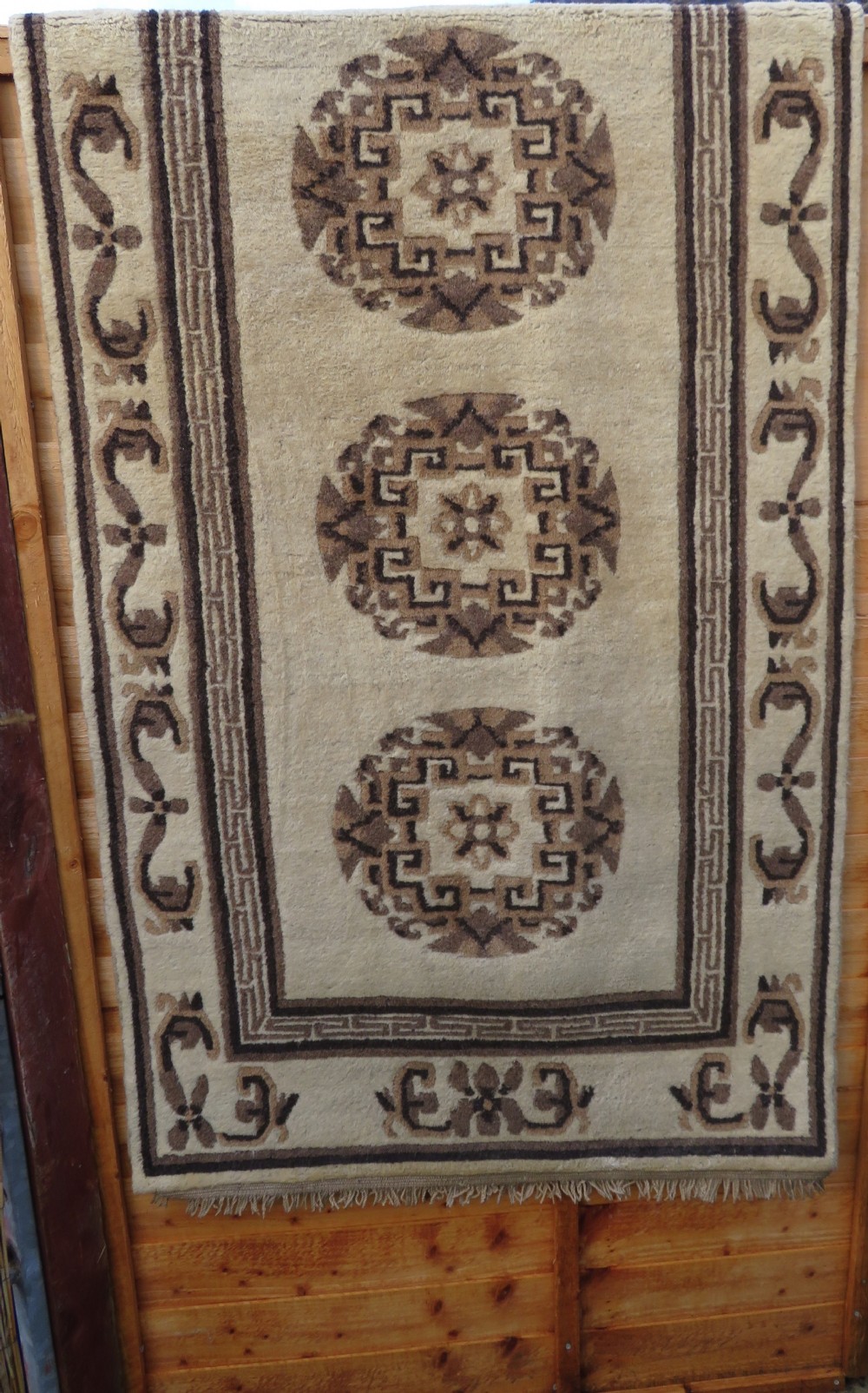 A rectangular hand-knotted wool rug runner featuring three central brown circular medallions on a cream background with a geometric border. View XXIII