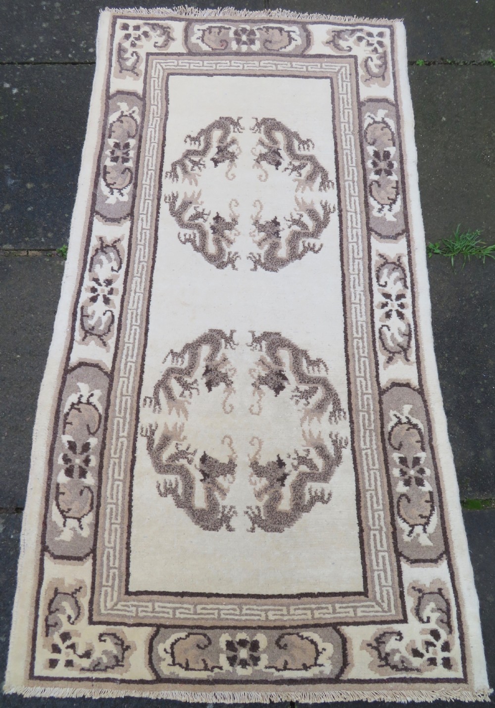 A rectangular hand-knotted cream wool rug featuring two central dragon medallions, a key meander border, and grey decorative motifs. View II