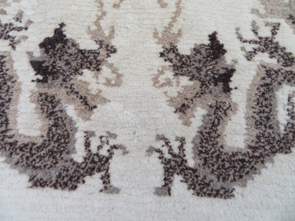 A rectangular hand-knotted cream wool rug featuring two central dragon medallions, a key meander border, and grey decorative motifs. View VI