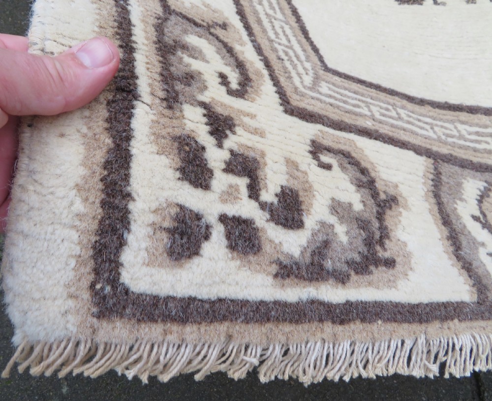 A rectangular hand-knotted cream wool rug featuring two central dragon medallions, a key meander border, and grey decorative motifs. View VIII