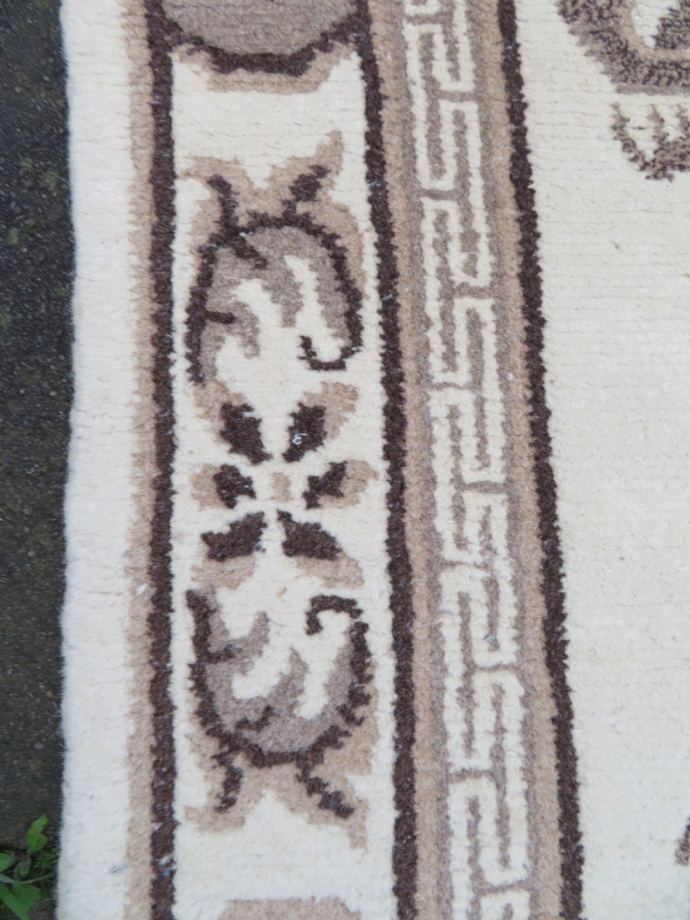 A rectangular hand-knotted cream wool rug featuring two central dragon medallions, a key meander border, and grey decorative motifs. View XII