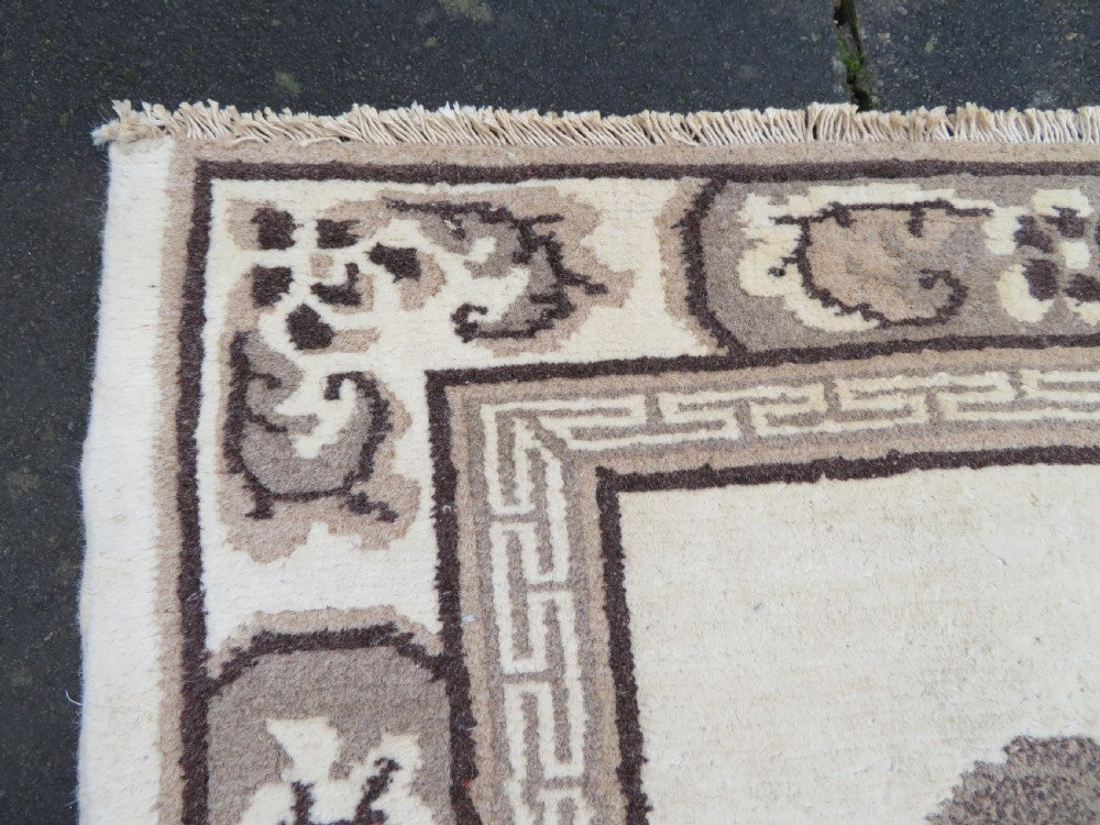 A rectangular hand-knotted cream wool rug featuring two central dragon medallions, a key meander border, and grey decorative motifs. View XIII