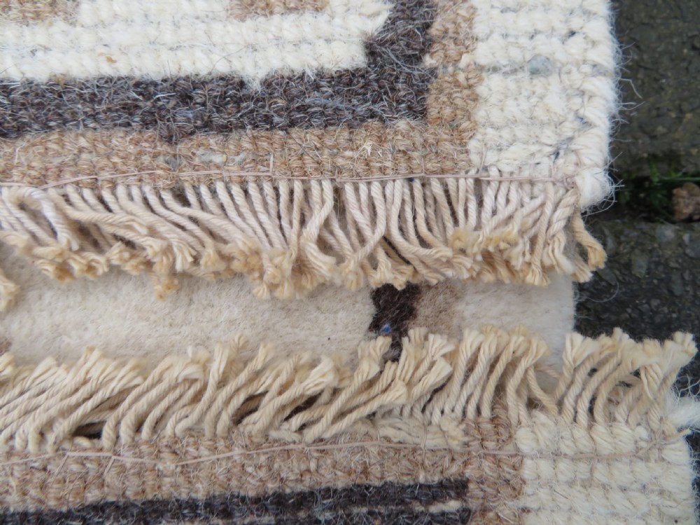 A rectangular hand-knotted cream wool rug featuring two central dragon medallions, a key meander border, and grey decorative motifs. View XVII