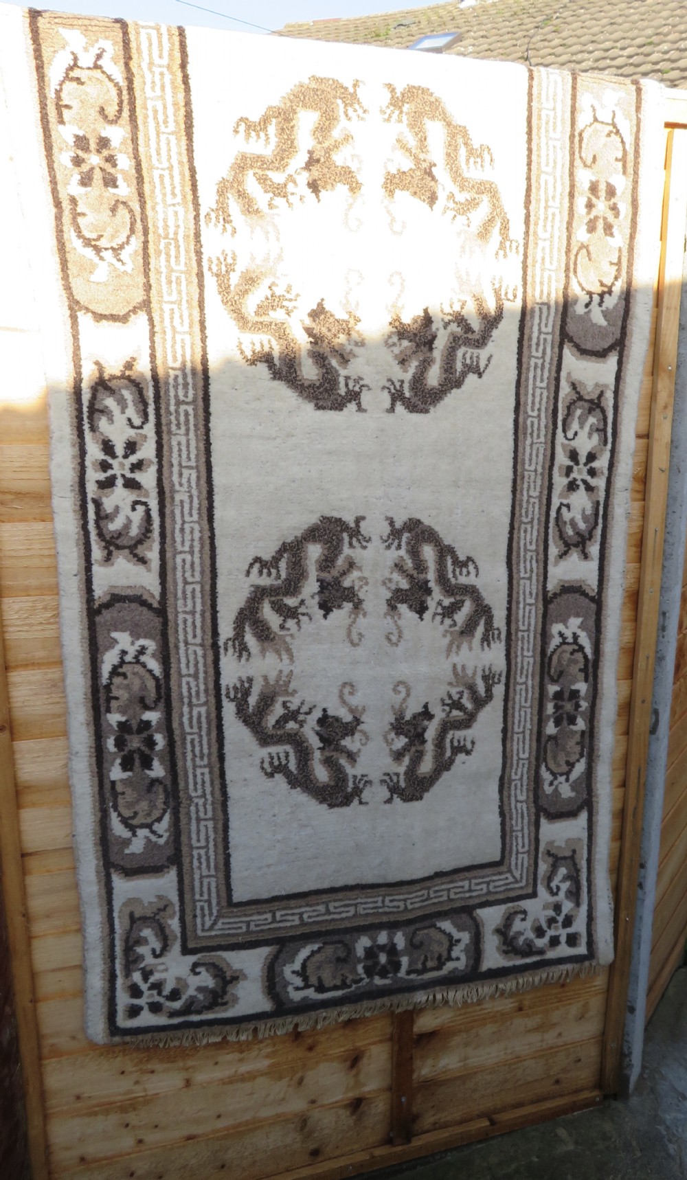 A rectangular hand-knotted cream wool rug featuring two central dragon medallions, a key meander border, and grey decorative motifs. View XXII