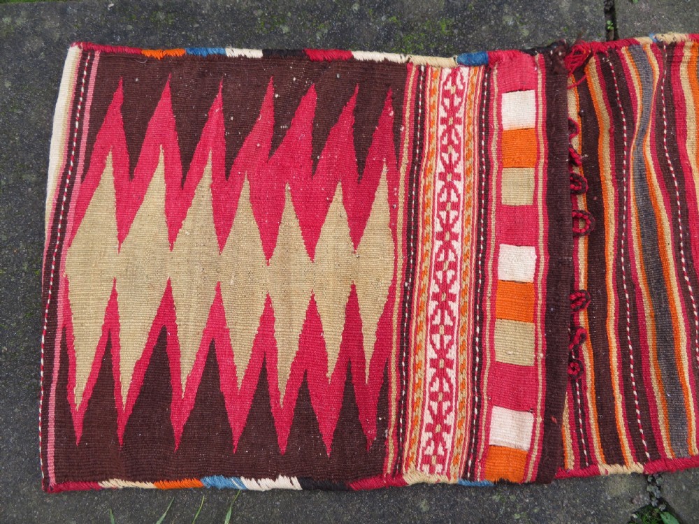 An antique woven wool Azerbaijan saddle bag displaying geometric serrated motifs in red, cream, and dark brown. View III