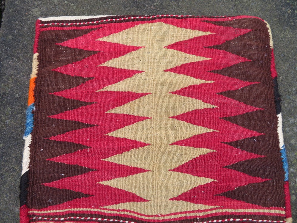 An antique woven wool Azerbaijan saddle bag displaying geometric serrated motifs in red, cream, and dark brown. View V